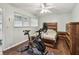 Bedroom with a wooden bed frame, matching dresser, and a Peloton bike on a stylish rug at 1900 59Th N Ave # 108, St Petersburg, FL 33714