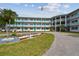 Three-story condominium building with teal doors, manicured landscaping, and ample parking at 1900 59Th N Ave # 108, St Petersburg, FL 33714