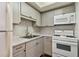 Efficient kitchen featuring white appliances, gray cabinets, and a stylish backsplash at 1900 59Th N Ave # 108, St Petersburg, FL 33714