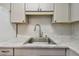 Close-up of a kitchen sink with marble countertops, stylish faucet, and modern backsplash at 1900 59Th N Ave # 108, St Petersburg, FL 33714