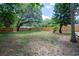 Expansive backyard with a tall wooden fence and mature trees at 1906 E Idlewild Ave, Tampa, FL 33610