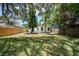 Spacious, grassy backyard with a privacy fence and mature trees at 1906 E Idlewild Ave, Tampa, FL 33610