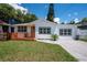 Charming single-story home featuring a new wood deck, fresh white paint, and black trimmed windows at 1906 E Idlewild Ave, Tampa, FL 33610