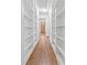 Hallway with hardwood floors and multiple built-in shelving units for storage at 1906 E Idlewild Ave, Tampa, FL 33610