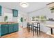 Kitchen showcasing teal cabinets, stainless appliances, modern finishes and an eat-in bar area at 1906 E Idlewild Ave, Tampa, FL 33610