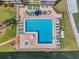 Aerial view of a community pool and jacuzzi offering ample lounge chairs and manicured landscaping at 19701 Gulf Blvd # 210, Indian Shores, FL 33785