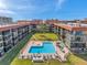 Aerial view of the community pool with jacuzzi surrounded by condos and green spaces at 19701 Gulf Blvd # 210, Indian Shores, FL 33785