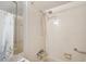 Tiled shower and tub featuring a shower head and grab bar at 19701 Gulf Blvd # 210, Indian Shores, FL 33785
