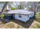 Features a screened in patio area, the home's exterior, and a grassy backyard at 2004 Nobleton Ave, Spring Hill, FL 34608