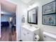 Stylish bathroom with a modern vanity, decorative mirror, and adjacent living space at 2004 Nobleton Ave, Spring Hill, FL 34608