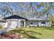 Charming single-story home with a well-manicured lawn and an attached garage, all shaded by mature trees at 2004 Nobleton Ave, Spring Hill, FL 34608