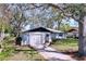 Beautiful white single-story home with a garage, complemented by a green lawn and shady mature trees at 2004 Nobleton Ave, Spring Hill, FL 34608