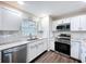 Modern kitchen with stainless steel appliances, white cabinetry, and subway tile backsplash at 2004 Nobleton Ave, Spring Hill, FL 34608