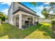 A spacious backyard with a covered patio that has a ceiling fan and outdoor seating options at 2140 Catalina Dr, Clearwater, FL 33764