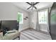 Light filled bedroom with light wood floors, a ceiling fan, large windows, and dark furniture at 2140 Catalina Dr, Clearwater, FL 33764