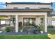 A covered patio with a seating swing, ceiling fan, and sliding glass doors to the interior of the house at 2140 Catalina Dr, Clearwater, FL 33764