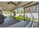 Relaxing covered patio with a ceiling fan, outdoor seating, and a view of the landscaped backyard with a privacy fence at 2140 Catalina Dr, Clearwater, FL 33764