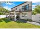 A modern two-story home with a balcony and covered patio, complimented by a lush lawn at 2140 Catalina Dr, Clearwater, FL 33764