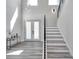 Bright foyer boasts soaring ceilings, modern light fixtures, and beautiful floors adjacent to staircase and frosted glass doors at 2140 Catalina Dr, Clearwater, FL 33764