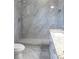 Bathroom features marble tiled shower, toilet and gray tile flooring at 2211 E 28Th Ave, Tampa, FL 33605