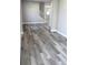 Bright living room featuring gray wood-look flooring and a modern staircase with white rails at 2211 E 28Th Ave, Tampa, FL 33605
