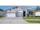 Exterior view of a two-story home, with a well-maintained lawn, paved driveway, and stone accents at 23231 Scaglione Dr, Lutz, FL 33549