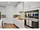 Modern kitchen with sleek white cabinetry, stainless steel appliances, and stylish backsplash at 23231 Scaglione Dr, Lutz, FL 33549