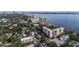 Aerial view showcasing condo buildings amidst lush greenery with a waterfront view of the city skyline at 2401 S Ardson Pl # 503, Tampa, FL 33629