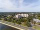 Condo building with waterfront access, lush greenery, and city skyline view from the road at 2401 S Ardson Pl # 503, Tampa, FL 33629