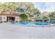 Community pool featuring a pool house with tables and chairs, landscaping, and lounge chairs with a bright blue sky at 2401 S Ardson Pl # 503, Tampa, FL 33629