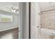 Bathroom with shower-tub combination and tiled walls, connected to bedroom with ceiling fan and wood floors at 2500 Harn Blvd # B11, Clearwater, FL 33764