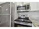 Updated kitchen appliances including a stainless steel refrigerator, oven, and microwave at 2500 Harn Blvd # B11, Clearwater, FL 33764