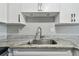 Close-up of kitchen area showcasing granite countertops, stainless steel sink, and white cabinets at 2500 Harn Blvd # B11, Clearwater, FL 33764