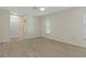 Spacious bedroom with light-colored walls, wood-look floors, closet, and natural light from windows at 2692 Royal Ridge Dr, Spring Hill, FL 34606