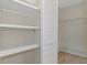Walk-in closet featuring white shelves, white shelving, and access to additional hanging storage at 2692 Royal Ridge Dr, Spring Hill, FL 34606