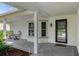 Covered front porch with sitting area and views of the landscaped yard at 2692 Royal Ridge Dr, Spring Hill, FL 34606