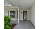 Covered front porch with gray patterned concrete and a brick facade at 2692 Royal Ridge Dr, Spring Hill, FL 34606