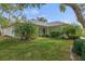 Single story home boasts a well-maintained lawn, landscaped beds and lush palm trees at 2692 Royal Ridge Dr, Spring Hill, FL 34606