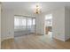 Open living room with light wood flooring, chandelier, and sliding doors to a sunroom at 2692 Royal Ridge Dr, Spring Hill, FL 34606