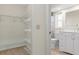 Walk-in closet with white wire shelving and an adjoining bathroom with a marble countertop vanity at 2692 Royal Ridge Dr, Spring Hill, FL 34606
