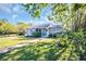 Beautiful home exterior with lush green lawn, manicured garden, concrete walkway and inviting blue front door at 2700 56Th S St, Gulfport, FL 33707