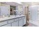Bright bathroom with double sink vanity, granite countertops, and a walk-in shower providing a functional and contemporary space at 3024 Living Coral St, Wimauma, FL 33598