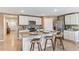 Bright kitchen features an island with granite countertops and seating for three at 3024 Living Coral St, Wimauma, FL 33598