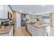Modern kitchen features an island with granite countertops and stainless steel appliances at 3024 Living Coral St, Wimauma, FL 33598