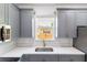 Close-up shot of a kitchen sink featuring stylish gray cabinets, quartz countertops, and gold fixtures at 3205 E North Bay St, Tampa, FL 33610