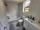 The remodeled bathroom showcases a tub, white marble-like tile, and updated fixtures with gray-toned floors at 321 Parkside Ln, Safety Harbor, FL 34695