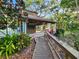 Exterior view of the cabana with its covered seating area, charming landscaping, and wooden walkway at 321 Parkside Ln, Safety Harbor, FL 34695
