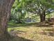 Scenic view of the pond with a glimpse of the cabana, trees, and greenery at 321 Parkside Ln, Safety Harbor, FL 34695