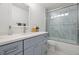 Updated bathroom featuring a marble-look shower and a modern blue vanity at 347 Patica Ne Rd, St Petersburg, FL 33702