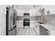 Modern kitchen with stainless steel appliances, sleek white cabinetry, and stylish backsplash at 347 Patica Ne Rd, St Petersburg, FL 33702